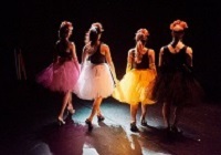 Drei Tänzerinnen und ein Tänzer tragen farbige Tutus. 