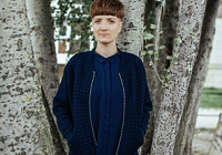 Autorin Sara Schurmann steht zwischen Bäumen.